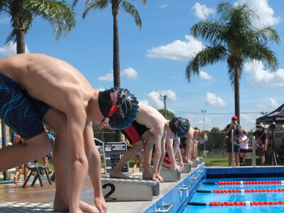 Boys preparing to dive from blocks